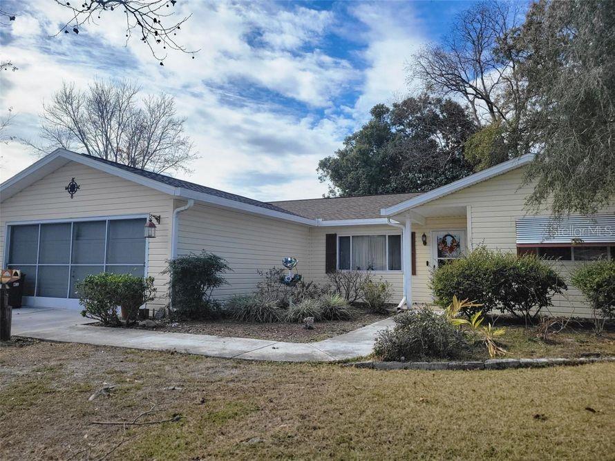 A single-story house with light yellow siding, a garage, and a front walkway — 10800 SW 62ND AVENUE, OCALA, FL