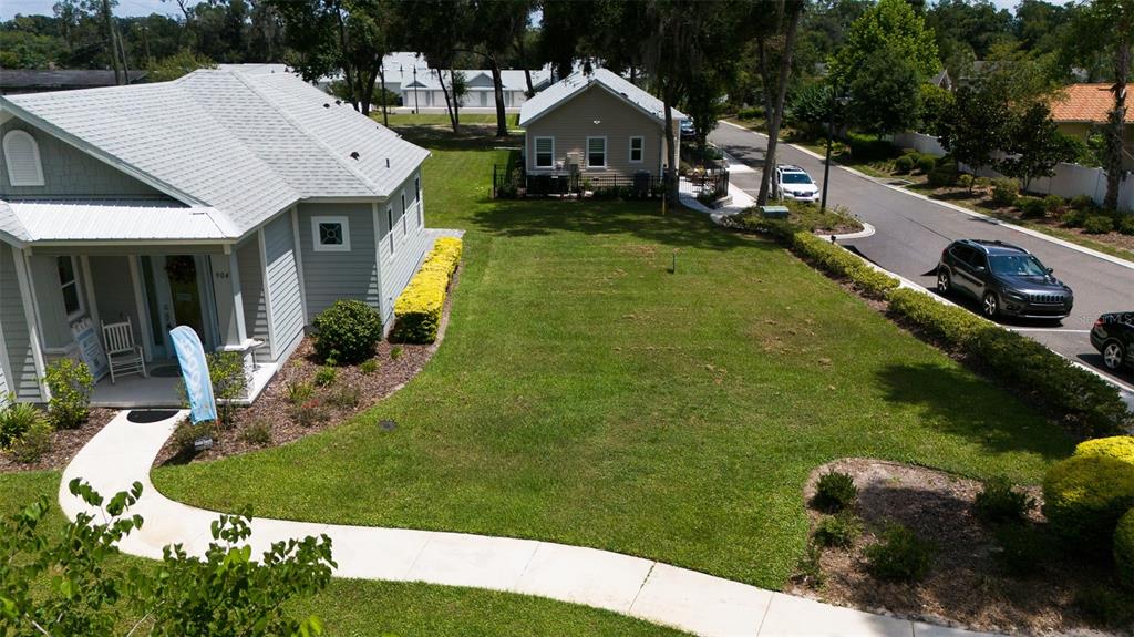 An aerial view shows a vacant grassy lot situated between two houses and a street — 900 AZALEA WALK CIR, DELAND, FL