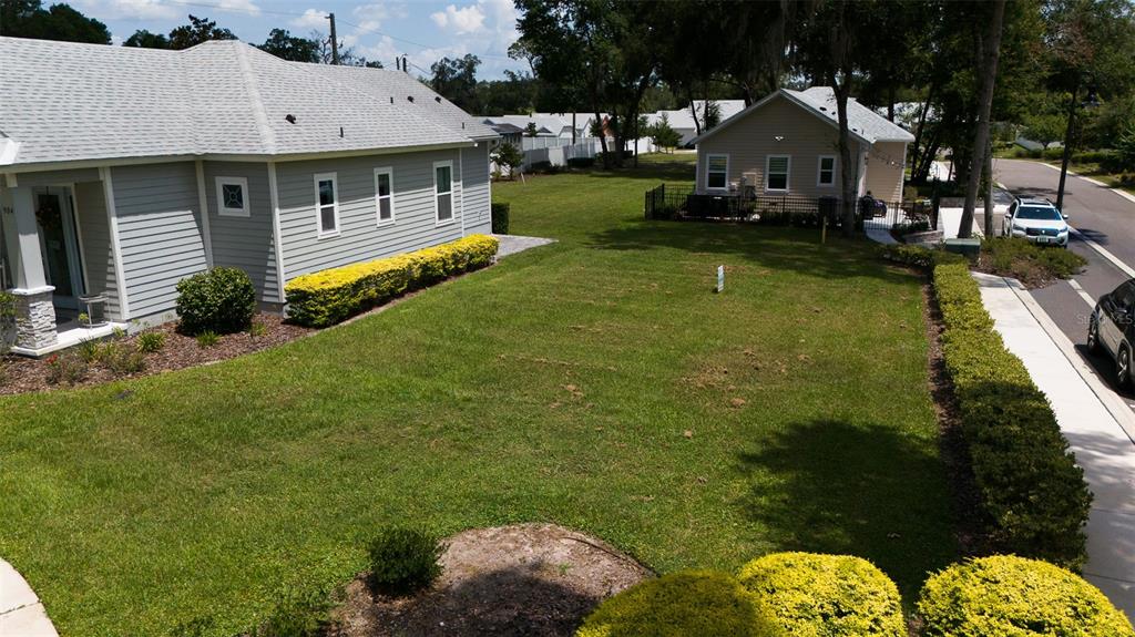 An aerial view shows a grassy side yard between two houses and a paved street — 900 AZALEA WALK CIR, DELAND, FL