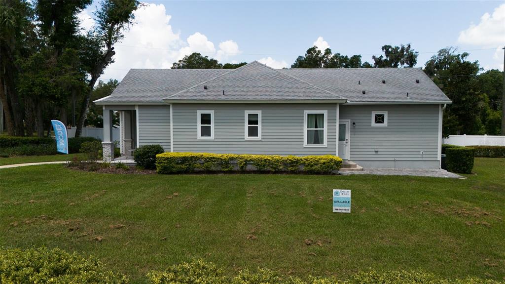 A single-story gray house with a shingled roof sits on a grassy lawn — 900 AZALEA WALK CIR, DELAND, FL