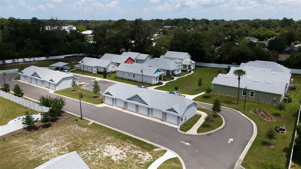 An aerial view shows a residential complex with several detached houses and garage buildings — 900 AZALEA WALK CIR, DELAND, FL