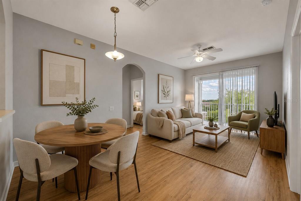 A living and dining area with light wood floors, neutral furniture, and a sliding glass door — 582 BRANTLEY TERRACE WAY UNIT 304, ALTAMONTE SPRINGS, FL