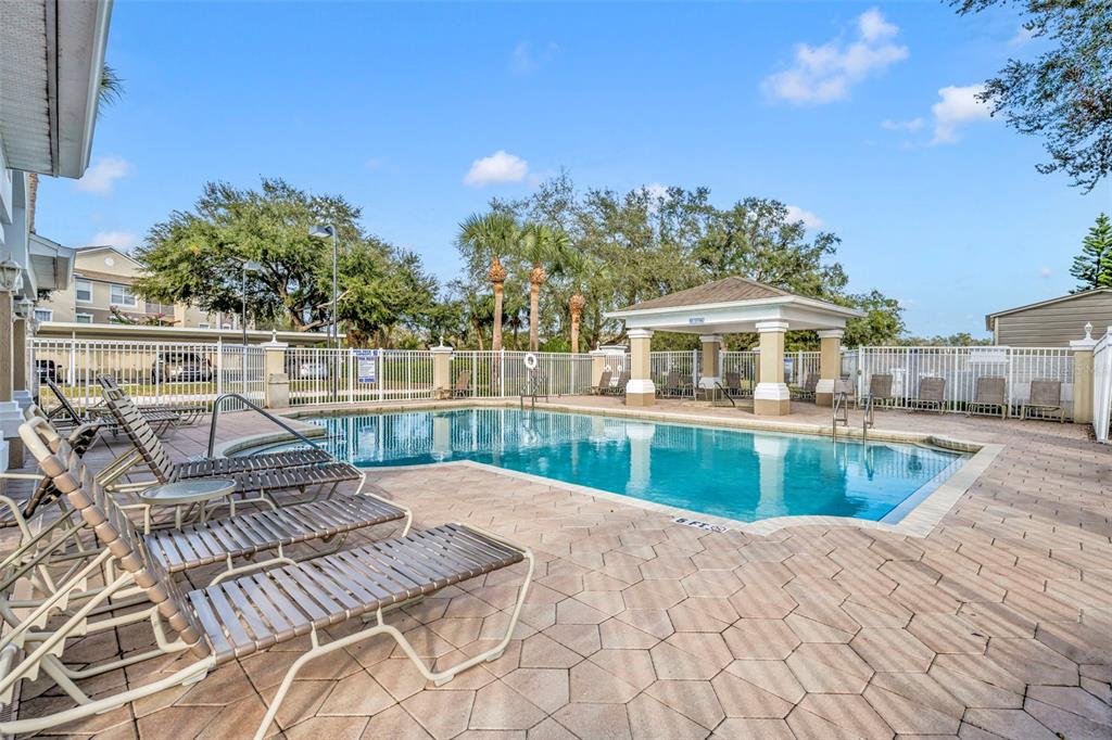 A swimming pool with a covered pavilion and lounge chairs on a paved deck — 582 BRANTLEY TERRACE WAY UNIT 304, ALTAMONTE SPRINGS, FL