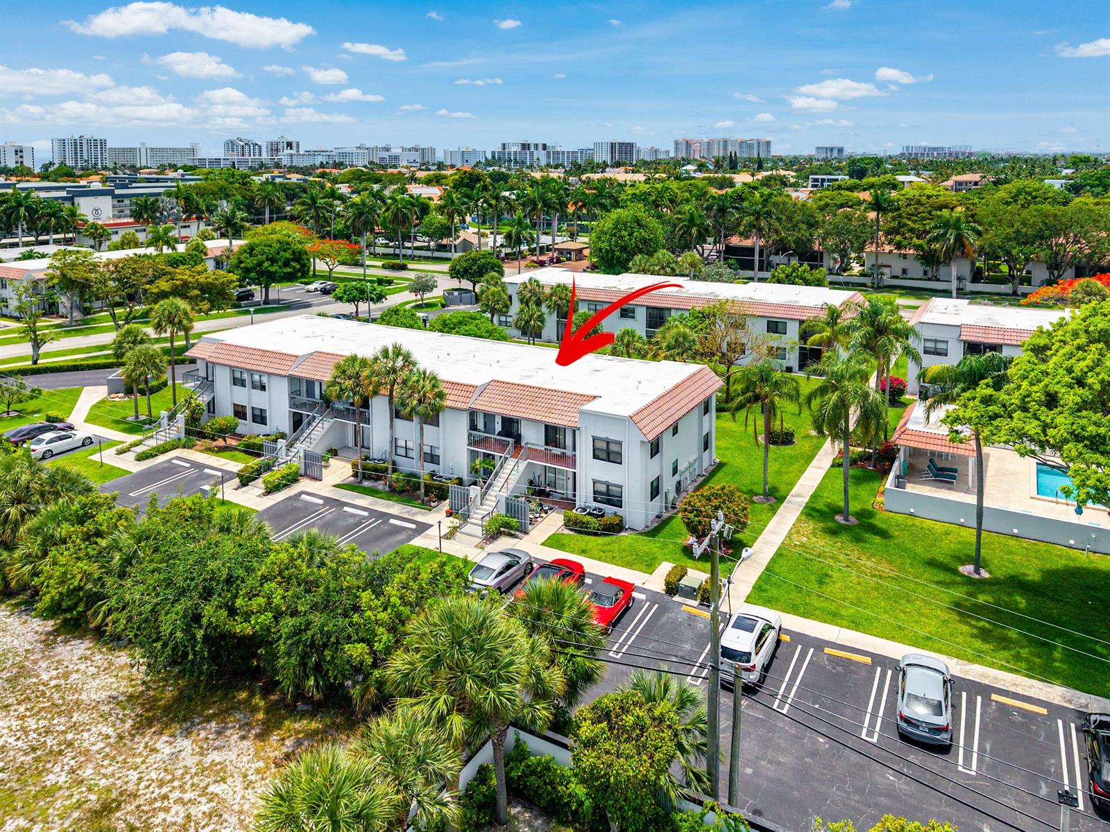 An aerial view of a multi-story apartment building with a red tile roof and parking — 3220 Frederick Boulevard # 49u, Delray Beach FL 33483, DELRAY BEACH, FL