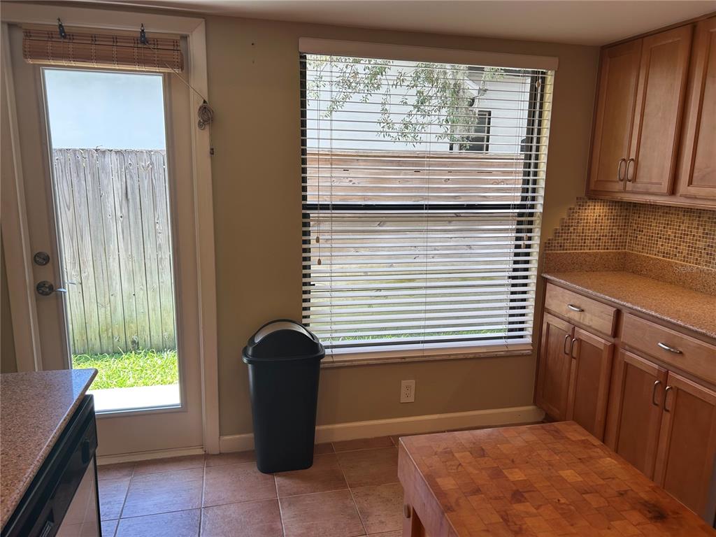 A patio area features a large tree, potted plants, and a gravel garden bed — 1850 BRYAN AVENUE, WINTER PARK, FL