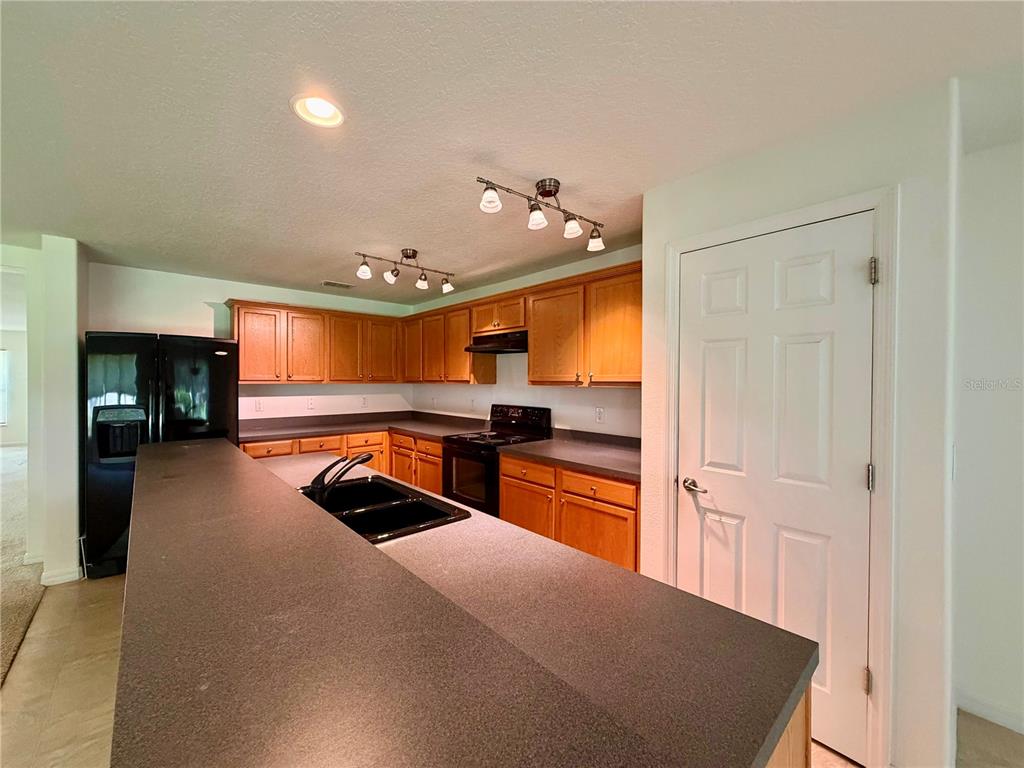 A living room with beige carpeting, white walls, and a tiled entryway — 2626 BREEZY MEADOW ROAD, APOPKA, FL