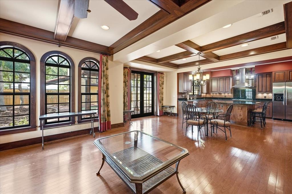 An open-concept kitchen and living area featuring wood floors, coffered ceilings, and arched windows — 1719 7TH STREET, SARASOTA, FL