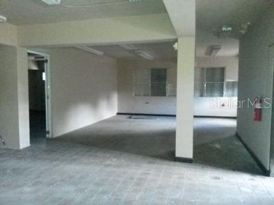 An empty, unfinished commercial space with concrete floors, white walls, and fluorescent ceiling lights — 10 VELA ST., SAN JUAN, PR