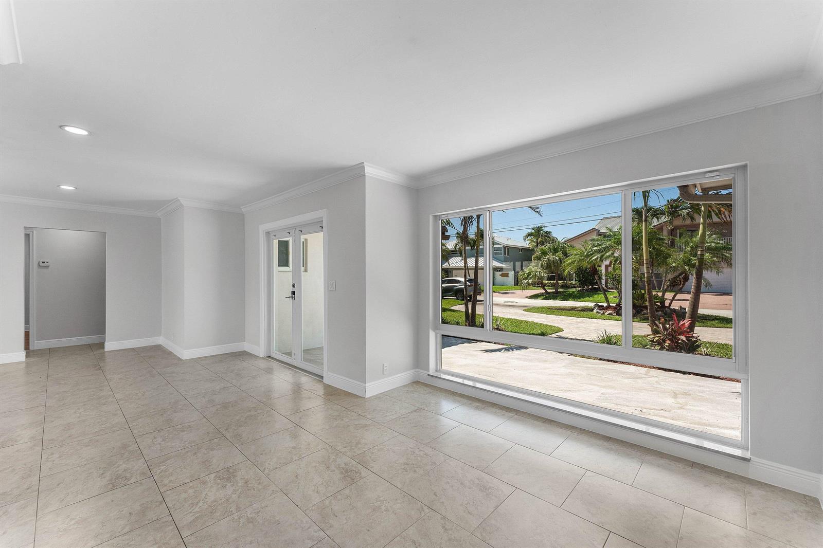 A bright, empty room features large windows, light-colored tile flooring, and white walls — 1525 SE 6th Street, Deerfield Beach FL 33441, DEERFIELD BEACH, FL