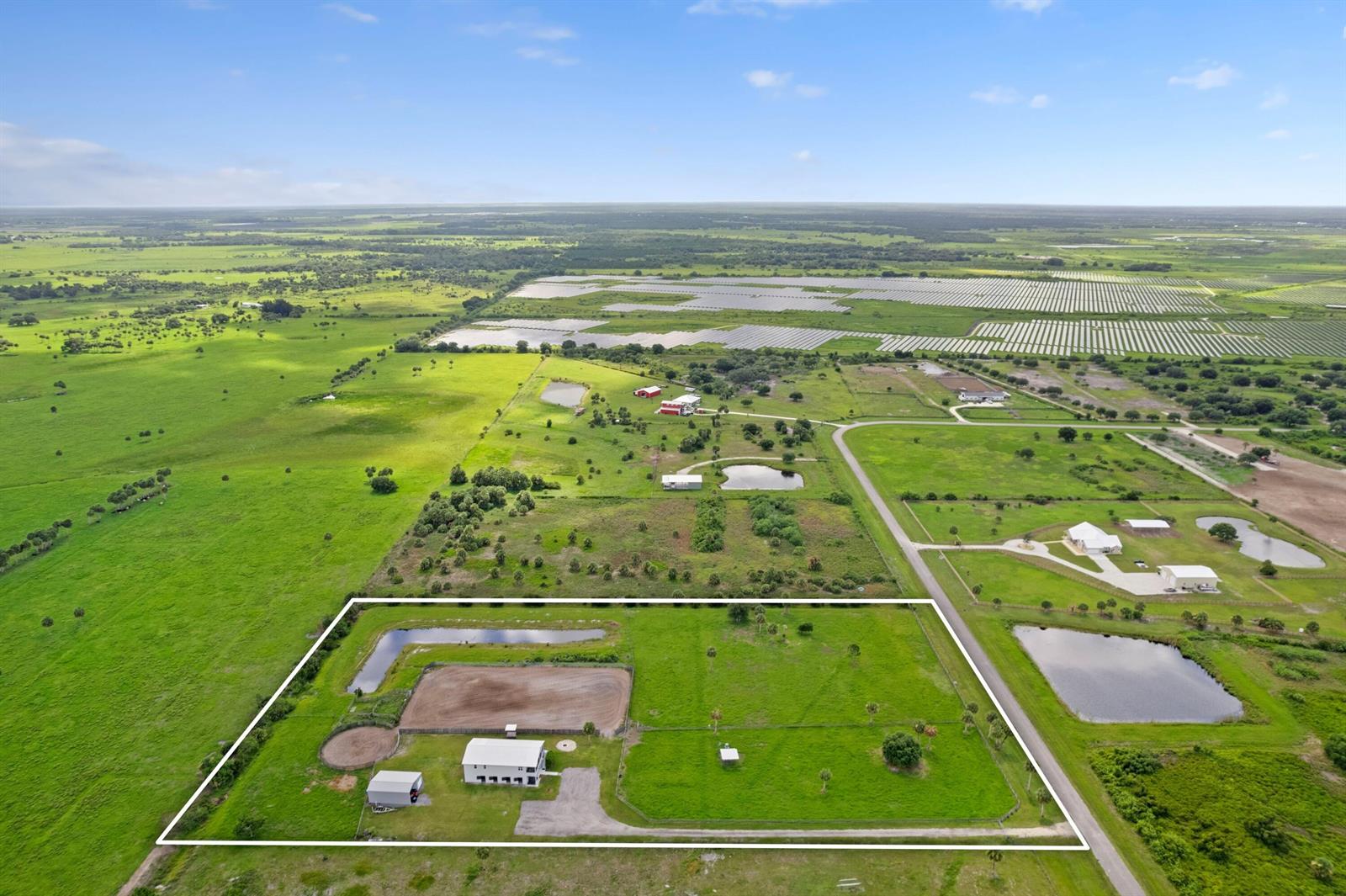 An aerial view shows a fenced rural property with a house, barn, and riding arena — 6536 SE 26th Trail, Okeechobee FL 34974, OKEECHOBEE, FL