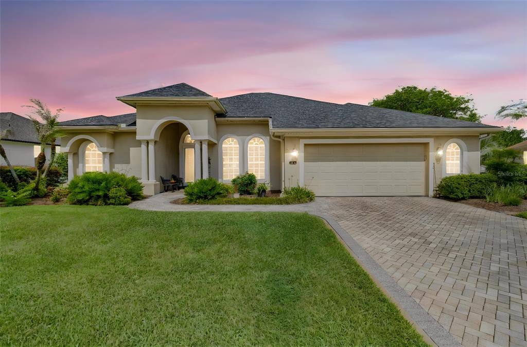 A single-story house with a beige stucco exterior, arched windows, and a paved driveway — 2349 CHESTERFIELD CIRCLE, LAKELAND, FL