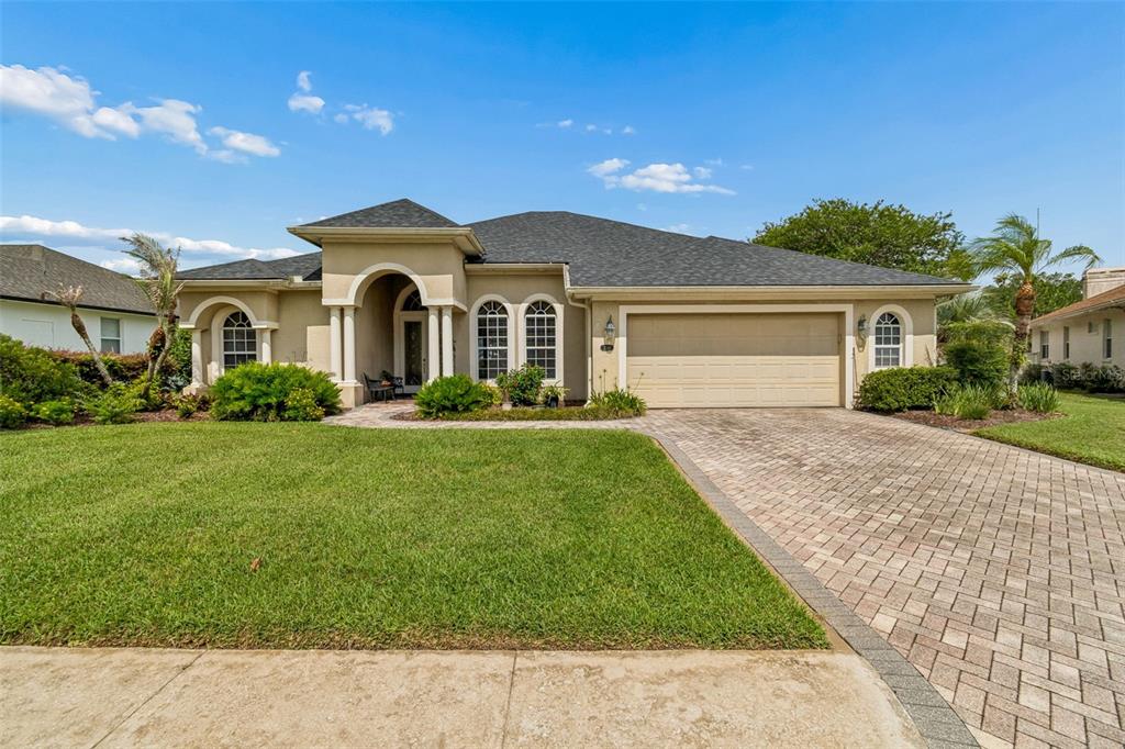 A single-story house with a beige stucco exterior, arched windows, and a paved driveway — 2349 CHESTERFIELD CIRCLE, LAKELAND, FL