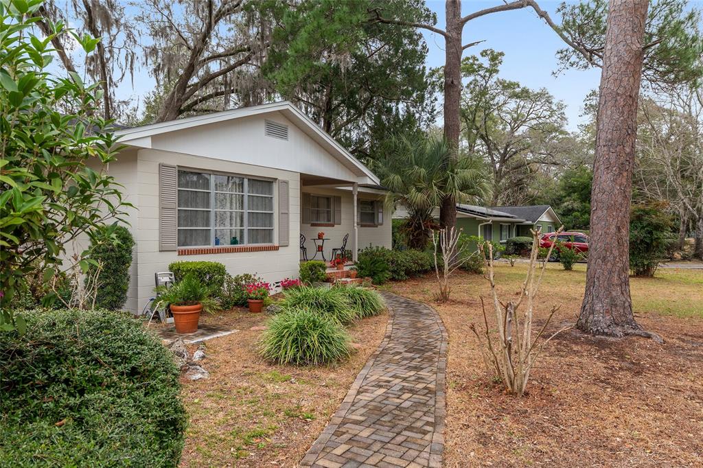 A single-story house with a brick walkway, beige siding, and a front porch — 3710 NW 22ND PLACE, GAINESVILLE, FL