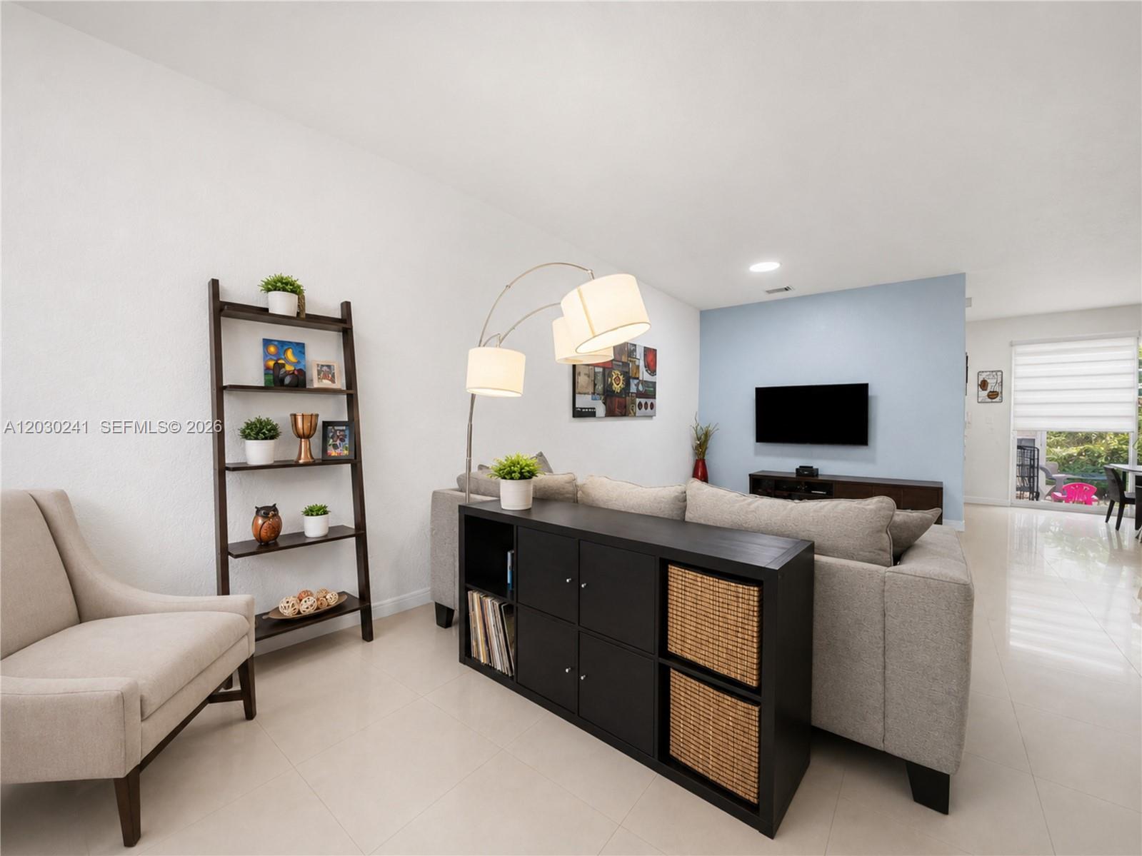 A living room features a grey sofa, a black console table, and a ladder shelf — 10918 NW 78th Ter, Doral FL 33178, DORAL, FL