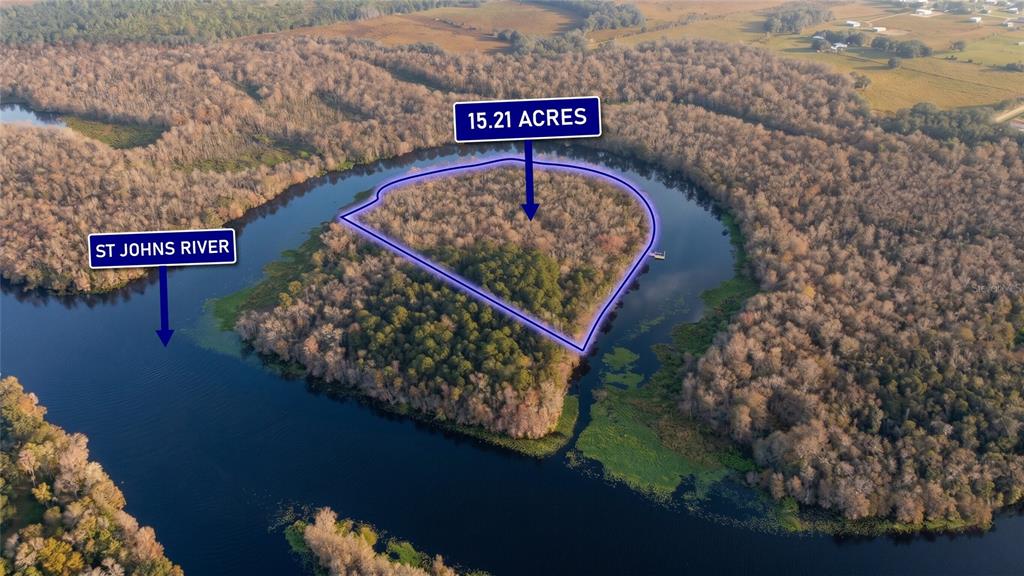 An aerial view shows a 15.21-acre wooded plot of land surrounded by the St. Johns River — 0000 CUMMER ROAD, DELAND, FL