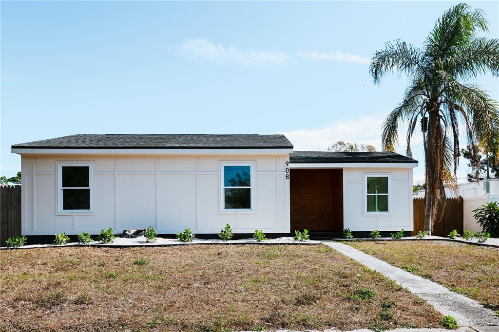 A single-story house with white board-and-batten siding, a dark roof, and a palm tree — 908 61ST STREET S, GULFPORT, FL