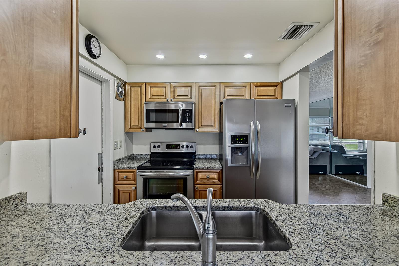 A kitchen features granite countertops, stainless steel appliances, and wood cabinetry — 2581 E Golf Boulevard, Pompano Beach FL 33064, POMPANO BEACH, FL