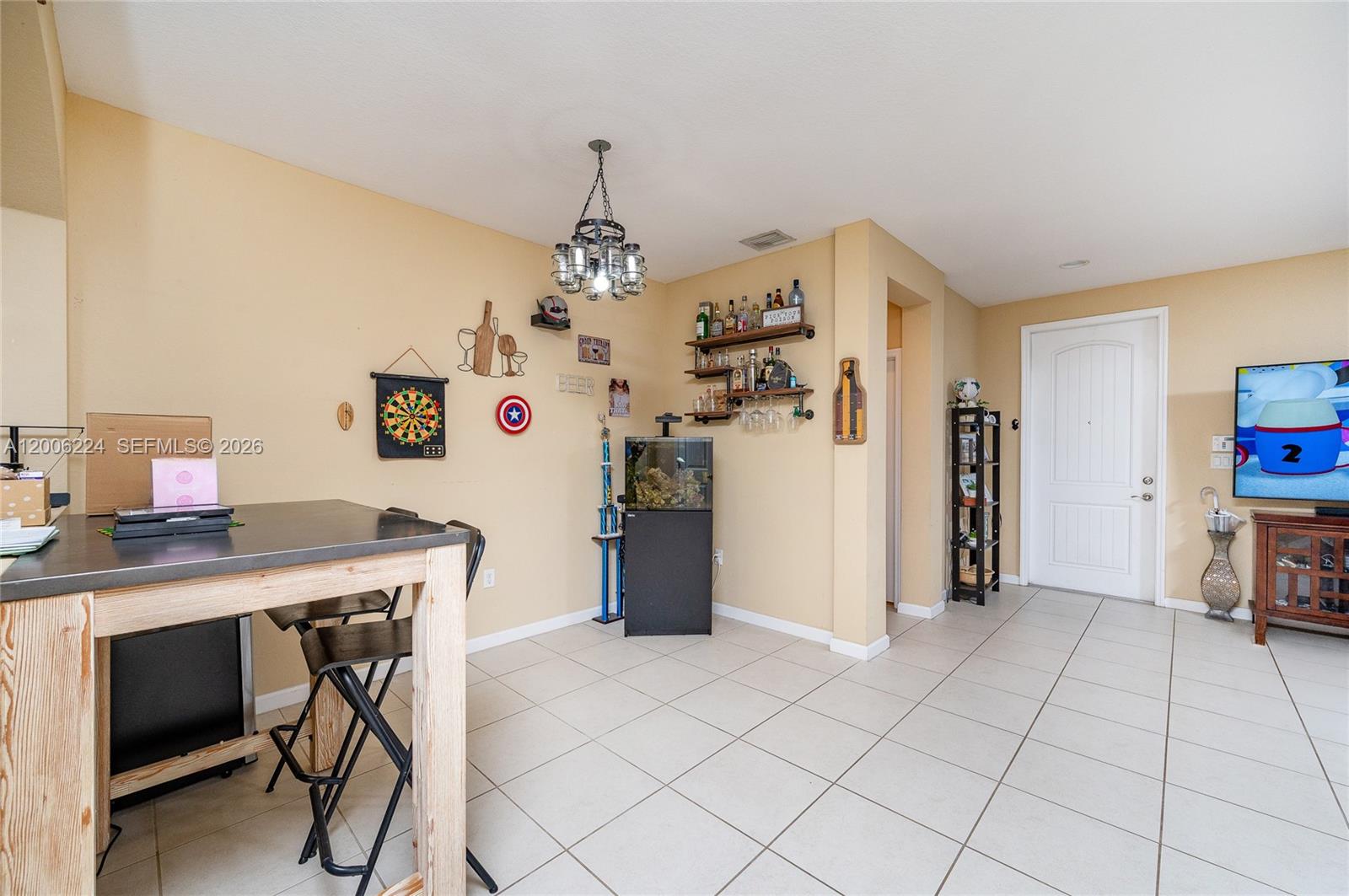 A room with tile flooring, a bar area, a dartboard, and a dining table — 27524 SW 140th Ave, Homestead FL 33032, HOMESTEAD, FL