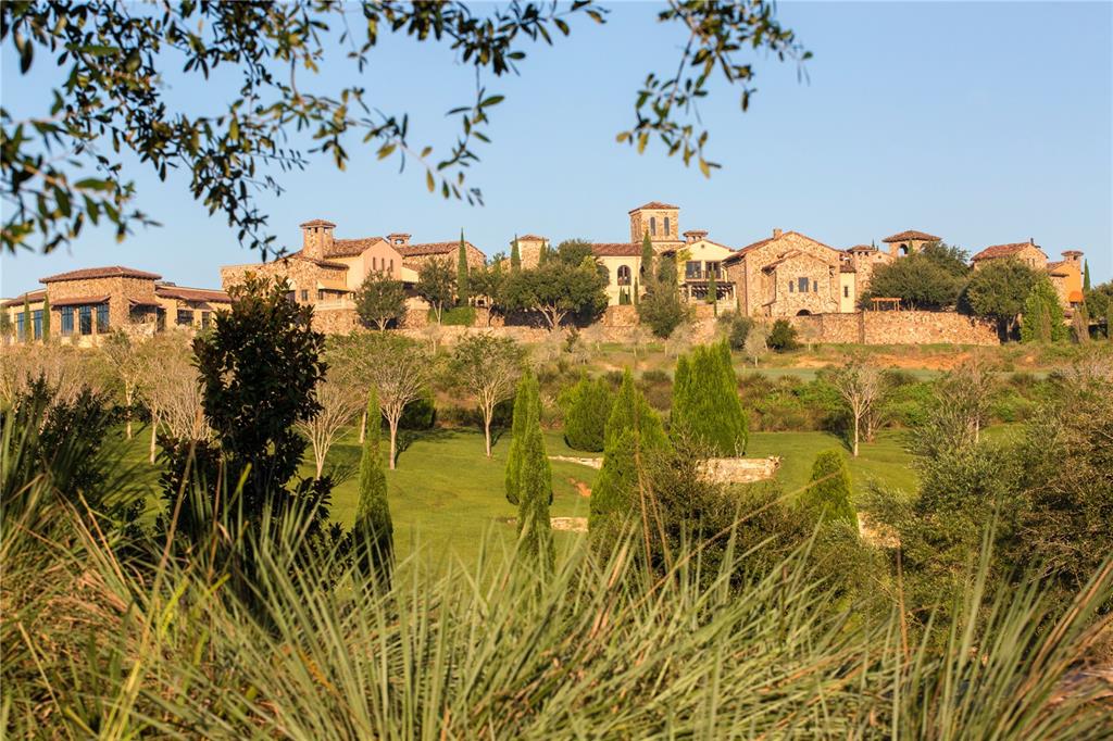 A large stone estate with multiple towers sits atop a hill overlooking a grassy landscape — 15393 APENNINE WAY, MONTVERDE, FL