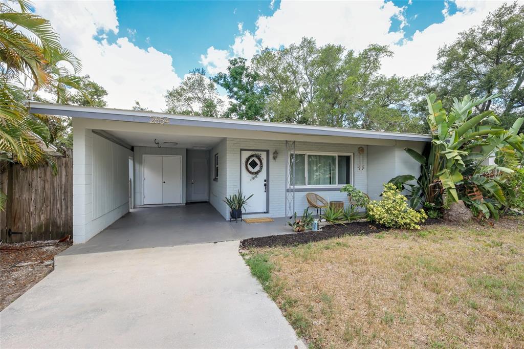 A single-story house features a white brick exterior, a carport, and a front yard — 2654 GRAND CAYMAN STREET, SARASOTA, FL