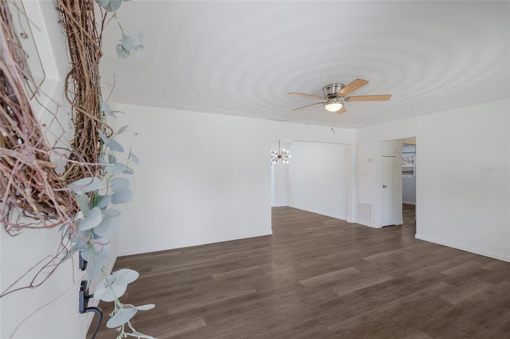 A living room with white walls, wood-look flooring, and a ceiling fan — 2654 GRAND CAYMAN STREET, SARASOTA, FL