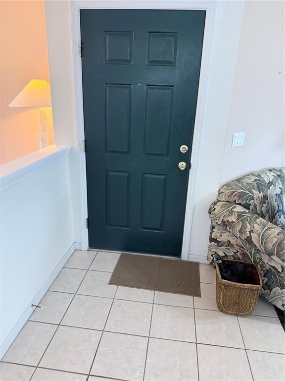 An entryway features a dark green door, tiled flooring, and a patterned sofa — 8844 GRAND PALMS CIRCLE UNIT A, KISSIMMEE, FL