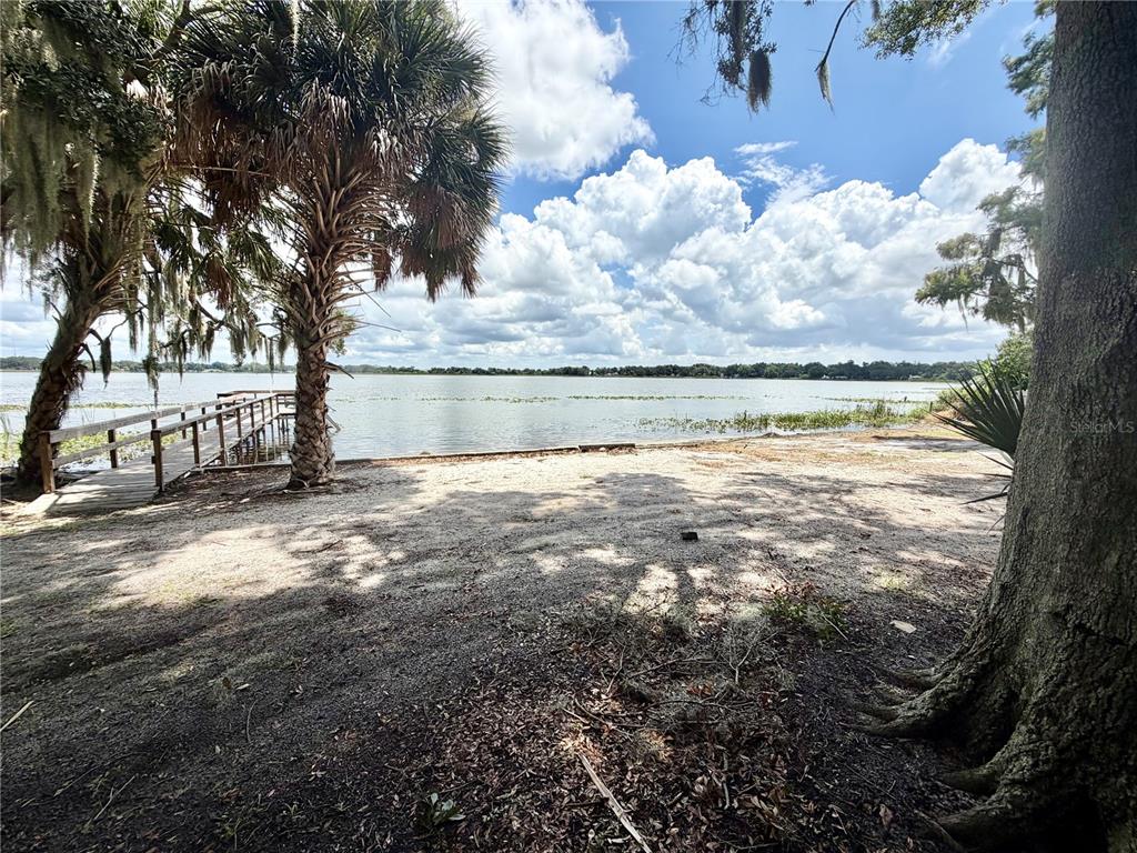 A wooden gazebo with a central bar overlooks a lake from a large deck — 1702 1/2 US HIGHWAY 92 W, AUBURNDALE, FL