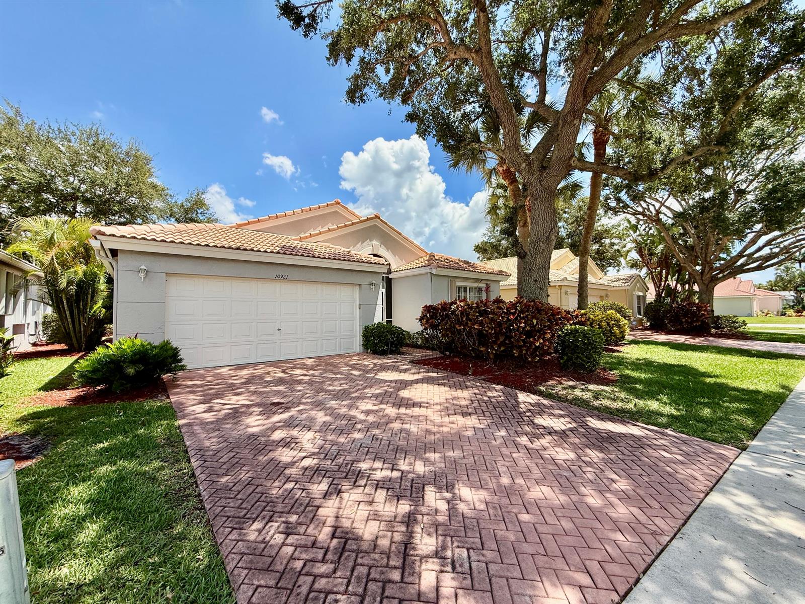 A single-story house with a tiled roof, white garage door, and a brick-paved driveway — 10921 Royal Caribbean Circle, Boynton Beach FL 33437, BOYNTON BEACH, FL