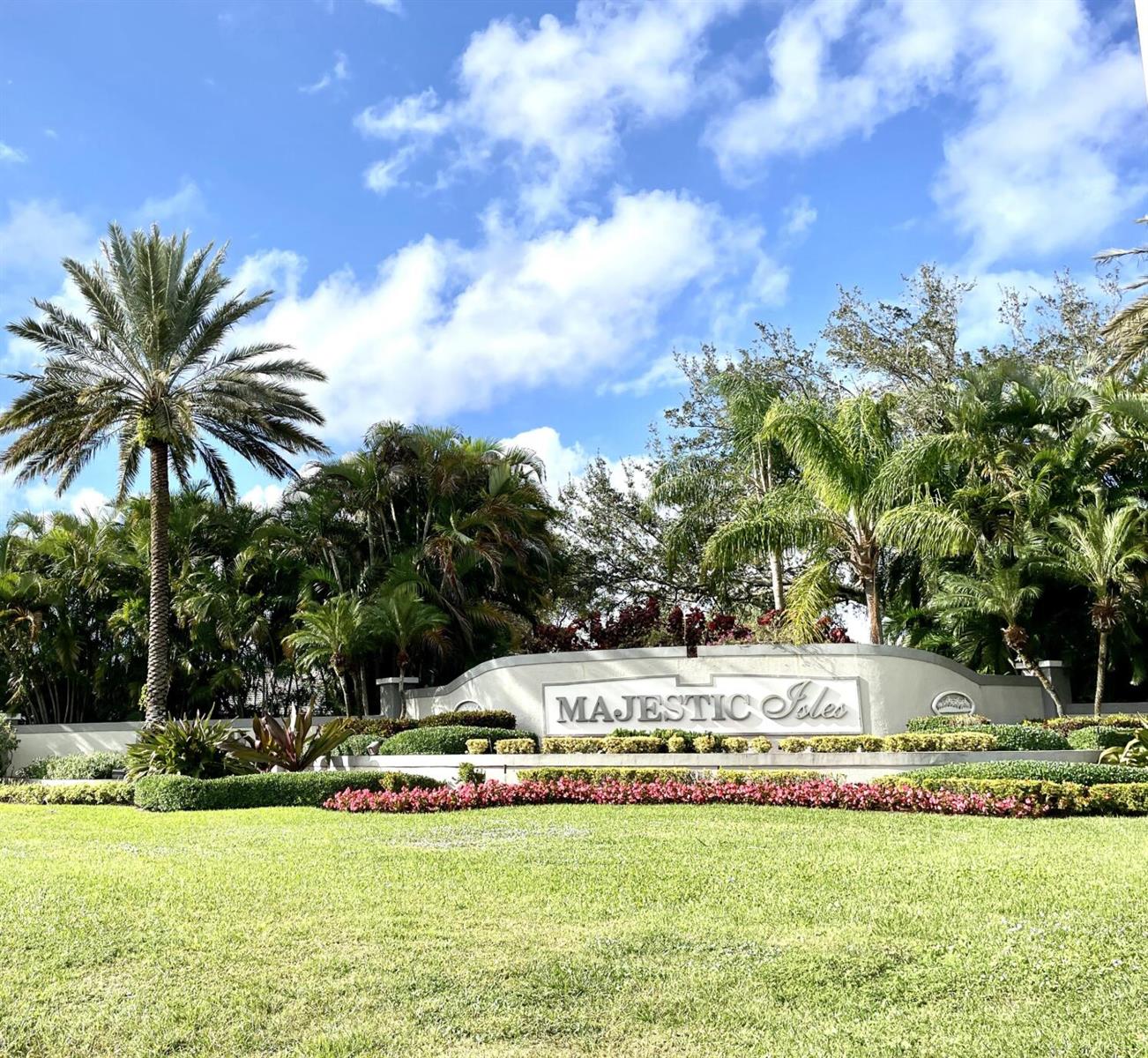 A landscaped entrance sign for Majestic Isles features palm trees and a manicured lawn — 10921 Royal Caribbean Circle, Boynton Beach FL 33437, BOYNTON BEACH, FL