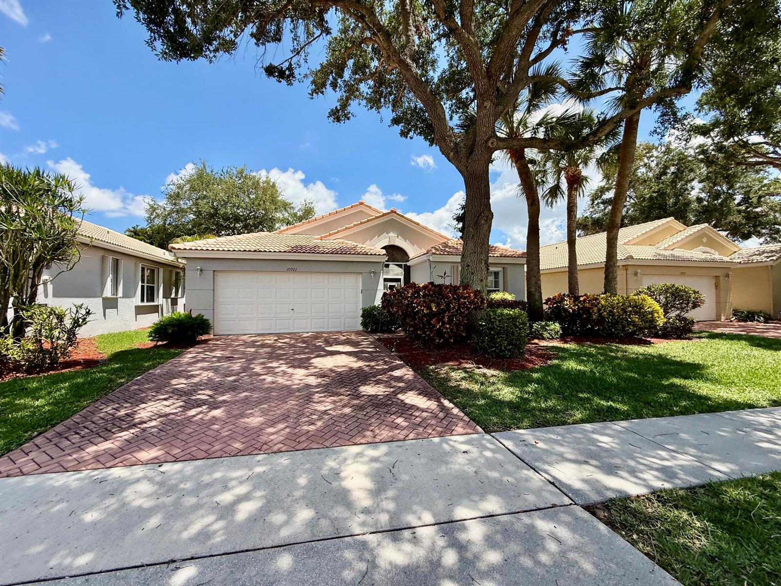 A single-story house with a white garage, tile roof, and a brick-paved driveway — 10921 Royal Caribbean Circle, Boynton Beach FL 33437, BOYNTON BEACH, FL