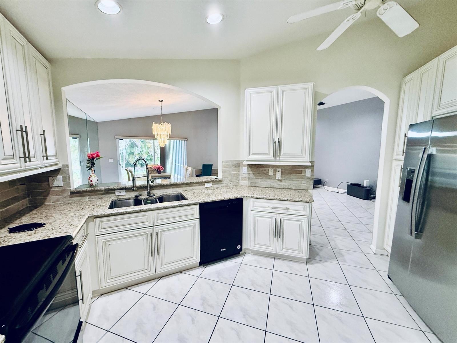 A kitchen with white cabinets, granite countertops, stainless steel appliances, and a black dishwasher — 10921 Royal Caribbean Circle, Boynton Beach FL 33437, BOYNTON BEACH, FL