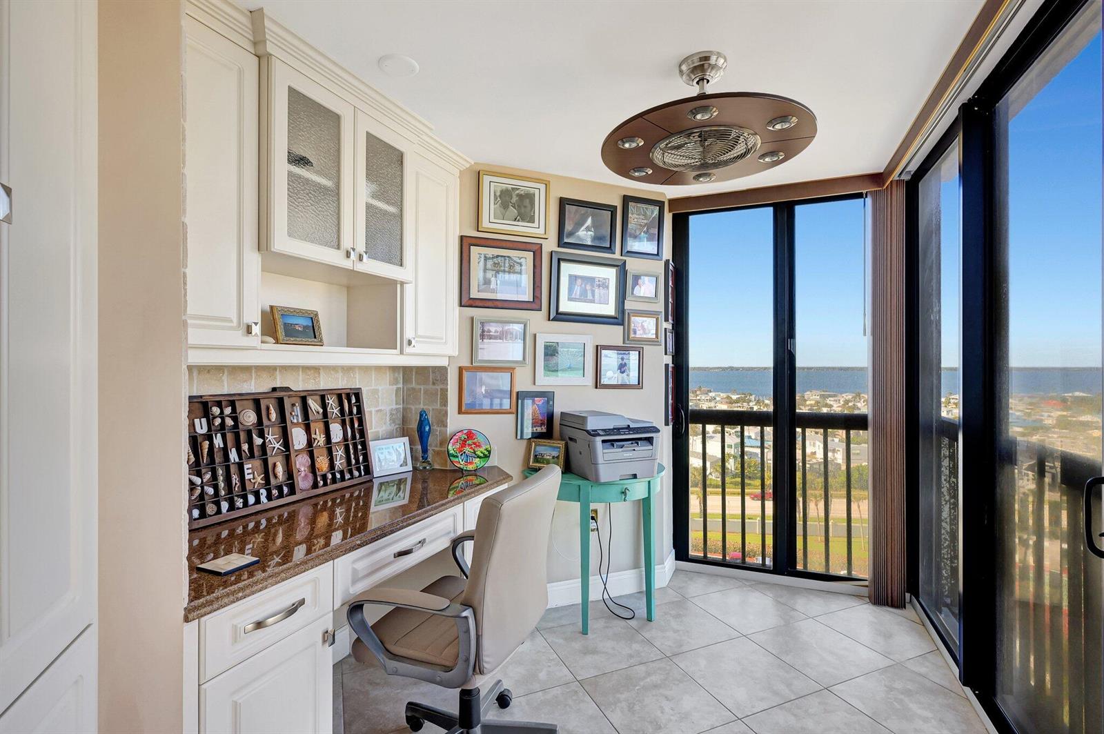A home office with built-in cabinetry, a granite desk, and a view of the water — 10680 S Ocean Drive # 901, Jensen Beach FL 34957, JENSEN BEACH, FL