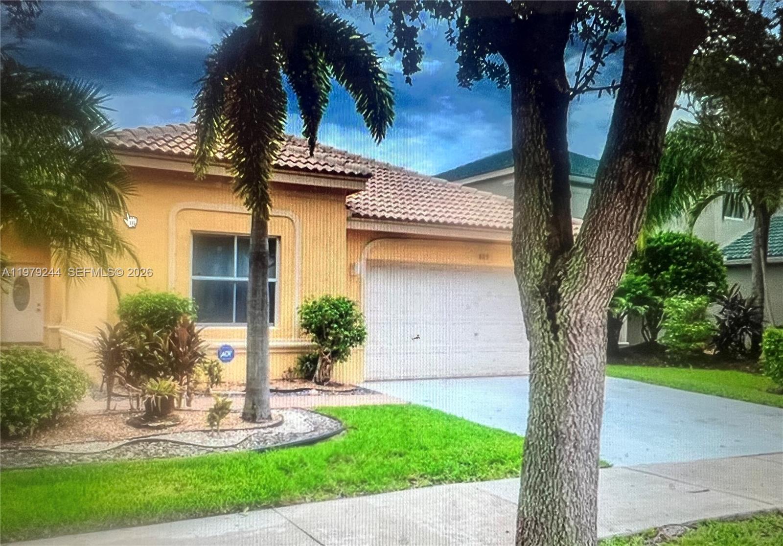 A yellow stucco house entrance features an arched entryway and a white front door — 803 Vista Meadows Dr, Weston FL 33327, WESTON, FL