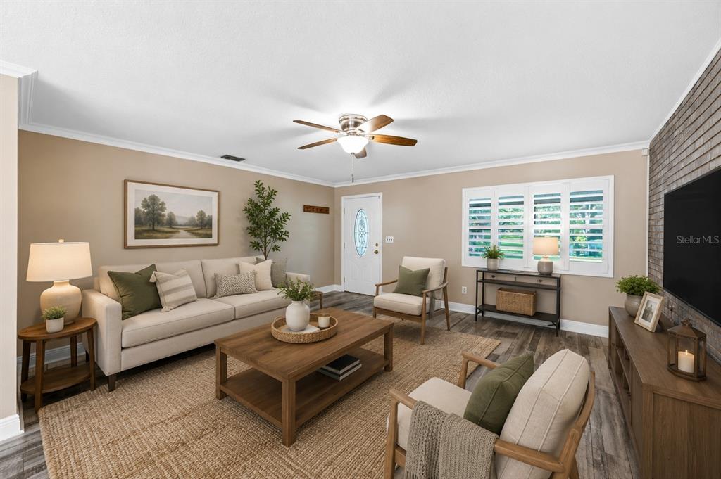 A living room features a beige sofa, two armchairs, a coffee table, and a brick wall — 5710 MOUNT OLIVE ROAD, POLK CITY, FL