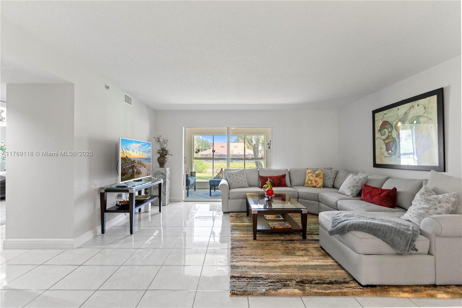 A living room features white tile floors, a large sectional sofa, and a glass-topped coffee table — 5876 Regal Glen Dr # 101, Boynton Beach FL 33437, BOYNTON BEACH, FL