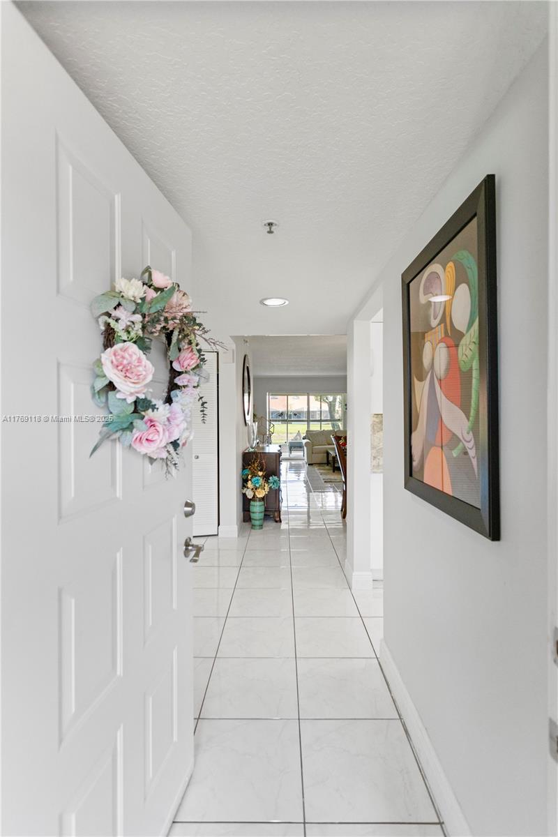 A white-tiled entryway leads into a bright living area with a view of the outdoors — 5876 Regal Glen Dr # 101, Boynton Beach FL 33437, BOYNTON BEACH, FL