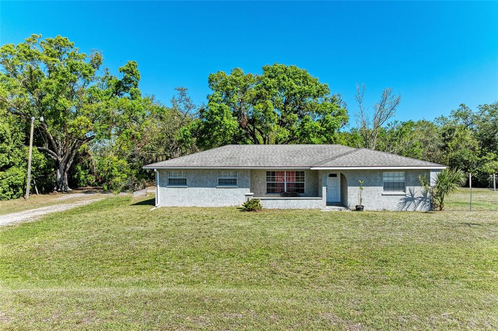 A single-story house with a gray stucco exterior and a gray shingled roof — 4007 45TH STREET E, BRADENTON, FL