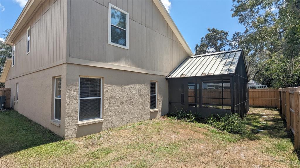 The exterior of a two-story house features a screened-in porch with a metal roof — 4029 QUAIL BRIAR DRIVE, VALRICO, FL