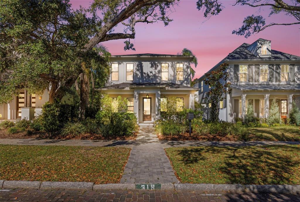 A two-story house with a front porch and a paved walkway at dusk — 319 12TH AVENUE NE, ST PETERSBURG, FL