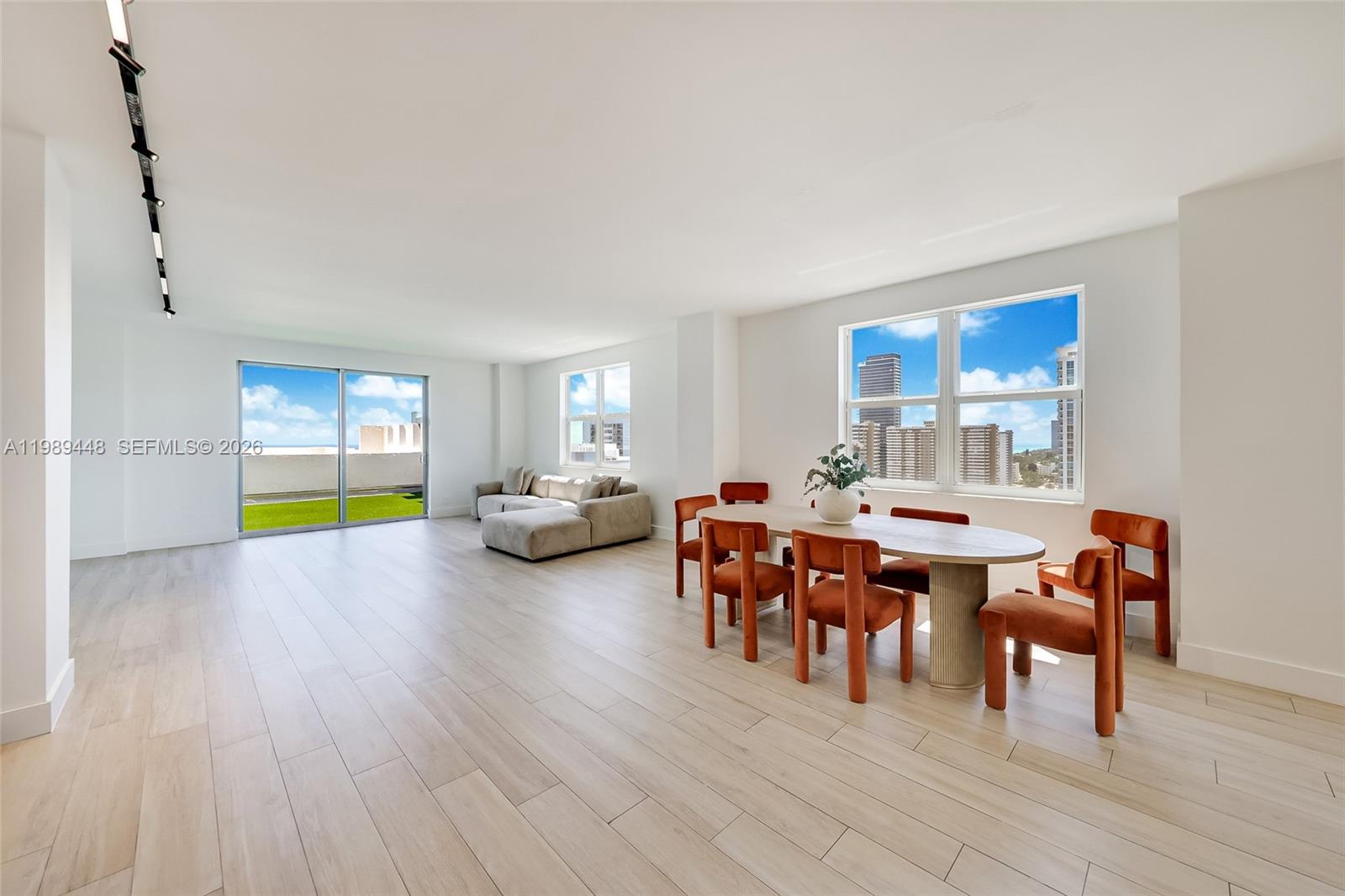 A modern kitchen features white cabinetry, a stone island, and a slatted wood base — 1865 S Ocean Dr # 21C, Hallandale Beach FL 33009, HALLANDALE BEACH, FL