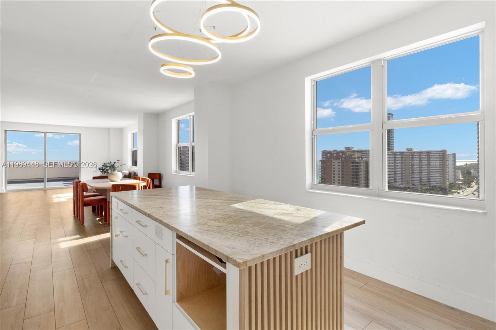 A bright, open-concept living and dining area features light wood floors and city views — 1865 S Ocean Dr # 21C, Hallandale Beach FL 33009, HALLANDALE BEACH, FL