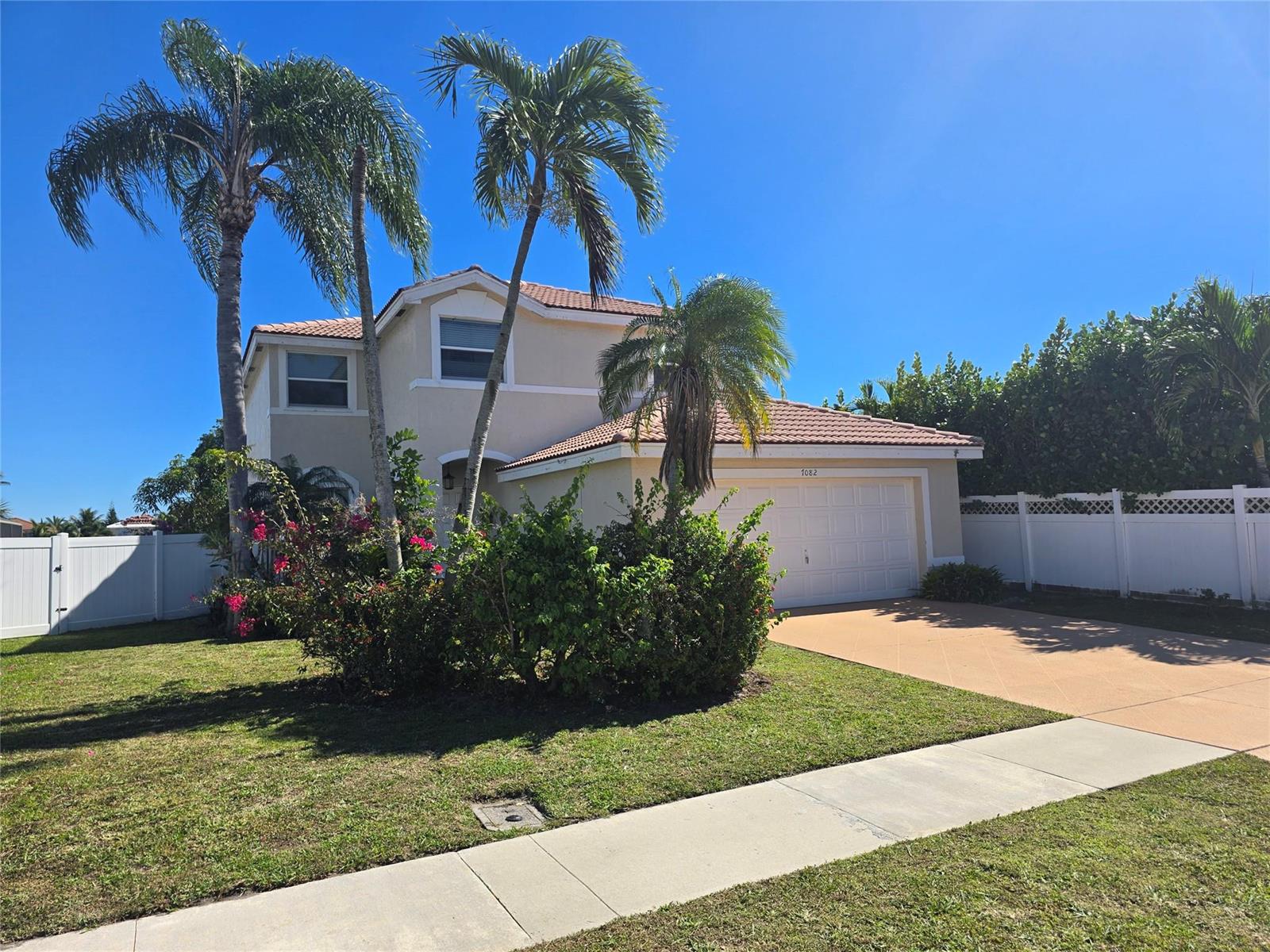 A two-story suburban house with a white garage, palm trees, and a front lawn — 7082 Middlebury Drive, Boynton Beach FL 33436, BOYNTON BEACH, FL