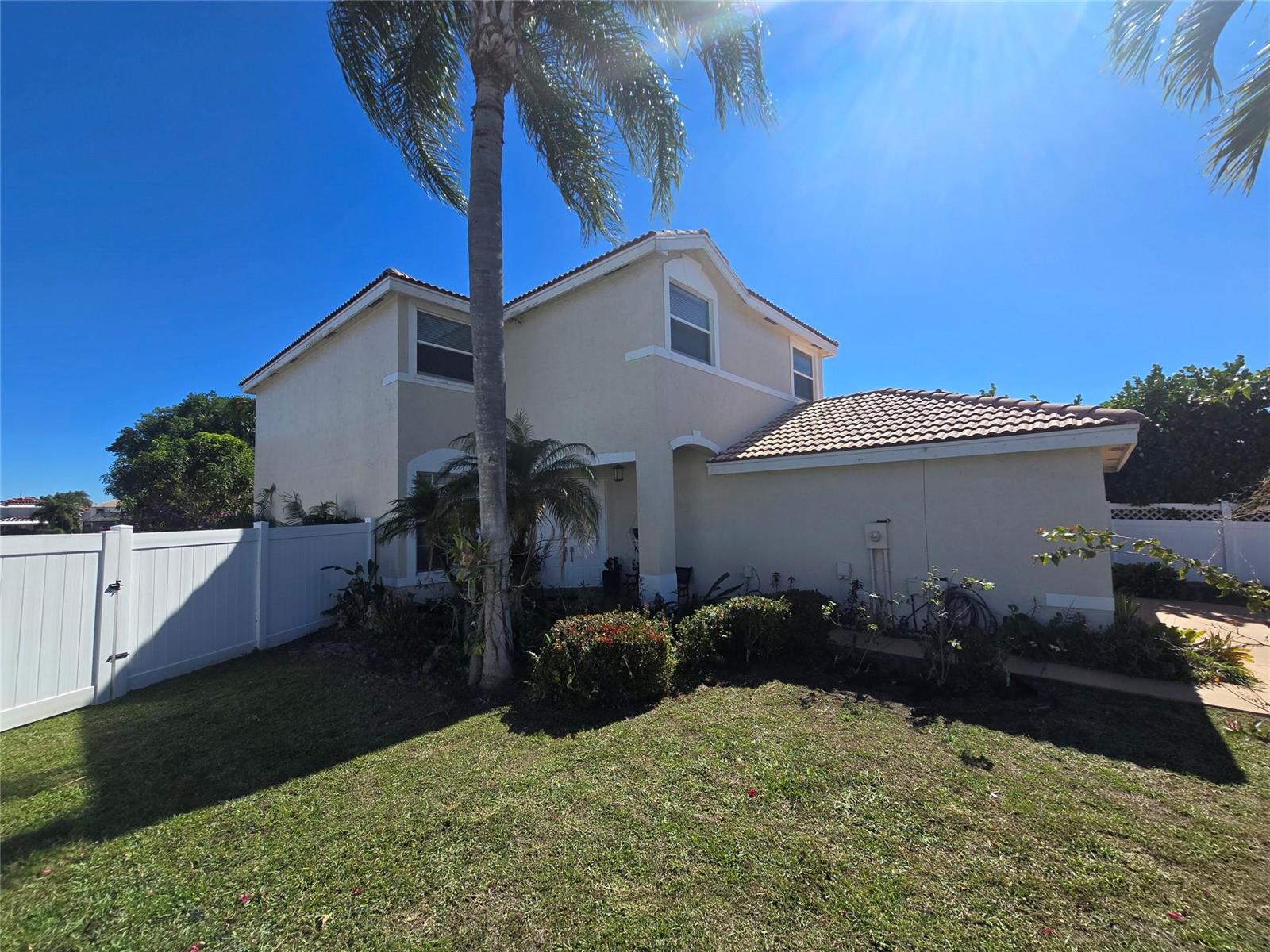 A two-story beige house with a tiled roof and a palm tree in the front yard — 7082 Middlebury Drive, Boynton Beach FL 33436, BOYNTON BEACH, FL