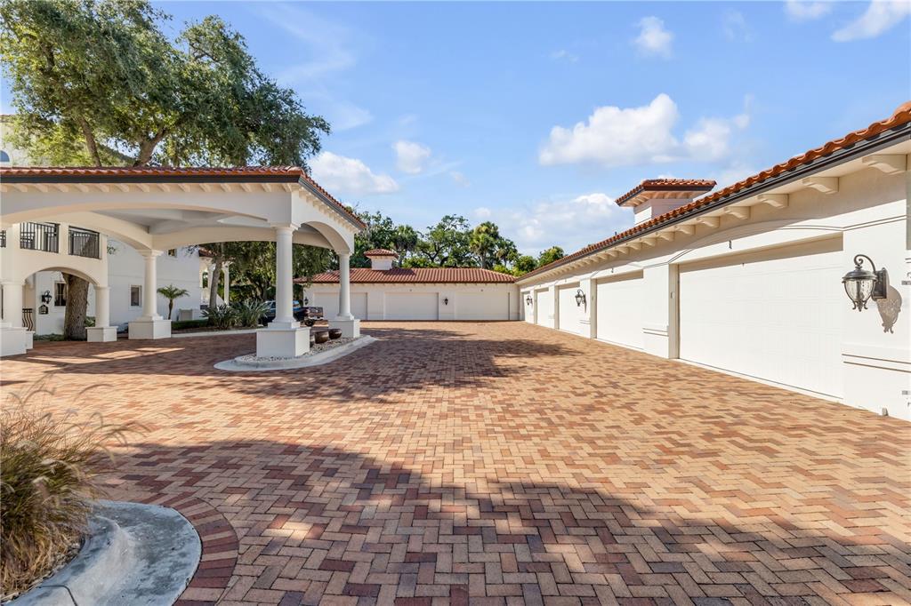 A paved driveway leads to a multi-car garage and a covered porte-cochère entrance — 5090 RIVERSIDE DRIVE UNIT 105, PORT ORANGE, FL