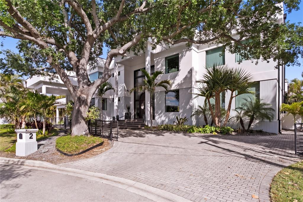 A large, two-story white modern house with a paved driveway and mature trees — 2 SANDPIPER ROAD, TAMPA, FL