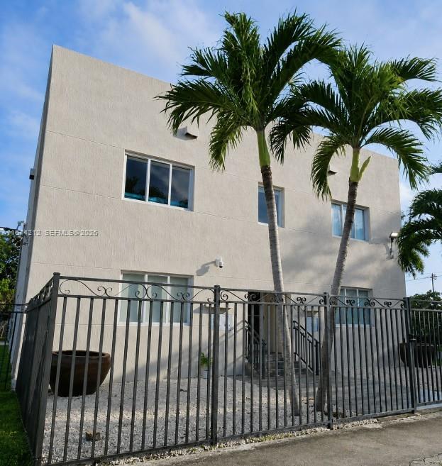 A two-story beige building with a metal fence and two palm trees in front — 2500 NE 192nd St, Miami FL 33180, MIAMI, FL