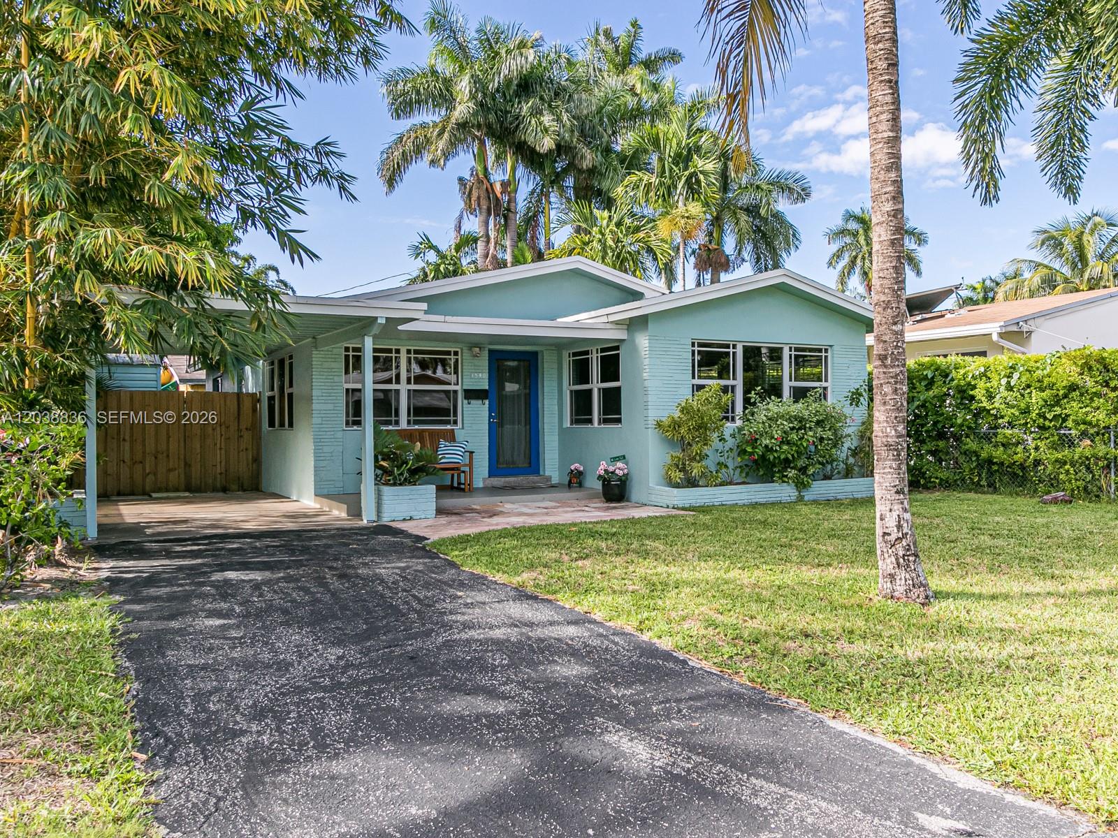 A light blue single-story house with a carport and a paved driveway — 1540 Arthur St, Hollywood FL 33020, HOLLYWOOD, FL