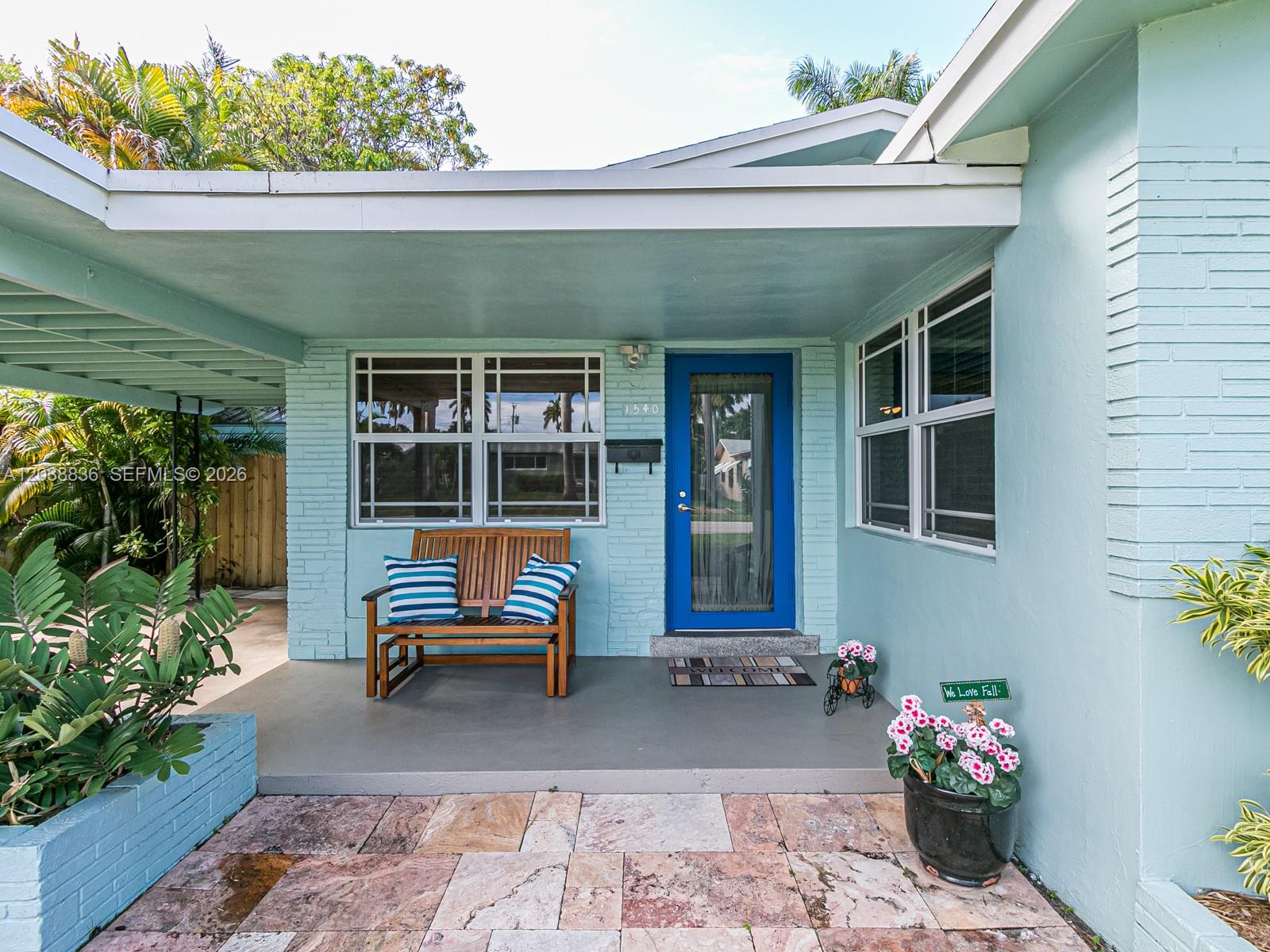 A light blue house exterior features a covered porch, a wooden bench, and a blue door — 1540 Arthur St, Hollywood FL 33020, HOLLYWOOD, FL