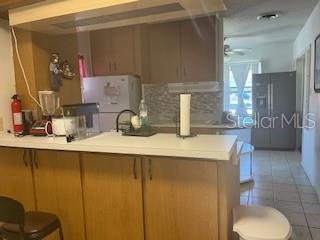 A kitchen features wood cabinets, a white countertop, and a stainless steel refrigerator — 2010 BLAIS AVENUE, DAYTONA BEACH, FL