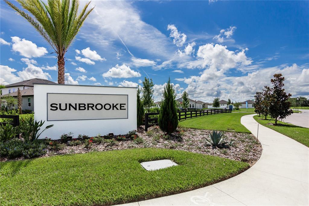 A white monument sign for Sunbrooke stands in a landscaped yard with a palm tree — 5816 BAR RANCH ROAD, ST CLOUD, FL